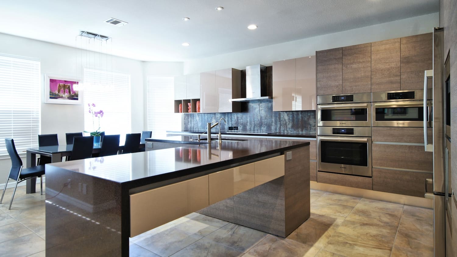 A kitchen with a large island and black appliances.